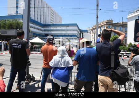 (190725) --TUNIS, le 25 juillet 2019 -- journalistes et citoyens se réunissent devant l'hôpital militaire tunisien de Tunis, Tunisie, le 25 juillet 2019. Le président tunisien Beji CAID Essebsi est décédé jeudi à l'âge de 92 ans à l'hôpital militaire de la capitale Tunis, a indiqué un communiqué de la présidence. Essebsi est né en novembre 1926 et a pris la présidence tunisienne après avoir remporté les élections de 2014. (Photo d'Adele Ezzine/Xinhua) TUNISIE-TUNIS-PRÉSIDENT-DÉCÈS huangxling PUBLICATIONxNOTxINxCHN Banque D'Images