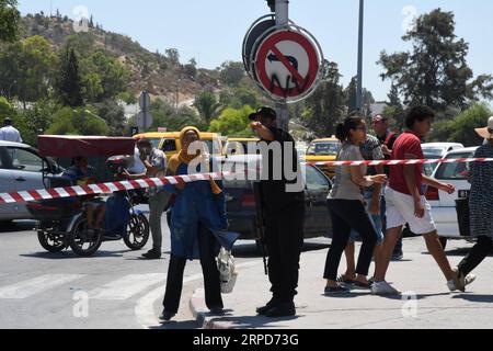 (190725) --TUNIS, le 25 juillet 2019 -- Un policier s'entretient avec une femme devant l'hôpital militaire tunisien de Tunis, Tunisie, le 25 juillet 2019. Le président tunisien Beji CAID Essebsi est décédé jeudi à l'âge de 92 ans à l'hôpital militaire de la capitale Tunis, a indiqué un communiqué de la présidence. Essebsi est né en novembre 1926 et a pris la présidence tunisienne après avoir remporté les élections de 2014. (Photo de /Xinhua) TUNISIE-TUNIS-PRÉSIDENT-DÉCÈS AdelexEzzine PUBLICATIONxNOTxINxCHN Banque D'Images