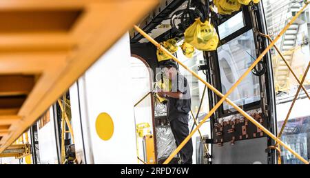 (190725) -- CHANGCHUN, le 25 juillet 2019 -- un ouvrier connecte les fils d'un wagon d'un train léger antidéflagrant sur rail dans un atelier de CRRC Changchun Railway Vehicles Co., Ltd. À Changchun, capitale de la province de Jilin du nord-est de la Chine, le 25 juillet 2019. Un train léger antidéflagrant qui sera exporté en Israël a quitté la chaîne de montage dans la ville de Changchun, au nord-est de la Chine, mardi. Le train, fabriqué par CRRC Changchun Railway Vehicles Co., Ltd., sera utilisé pour la ligne rouge du système de métro léger dans la ville israélienne de tel Aviv. La ligne de 23 km est prévue pour être mise en place Banque D'Images