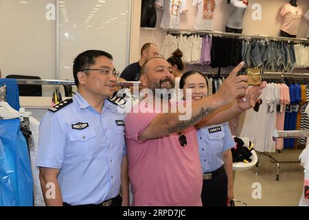 (190726) -- ZAGREB, 26 juillet 2019 -- des policiers chinois, effectuant une patrouille conjointe avec leurs collègues croates, posent pour des photos avec un client local dans un centre commercial vendant principalement des produits chinois à Zagreb, Croatie, le 25 juillet 2019. Des policiers croates et chinois ont commencé une patrouille conjointe pour la deuxième fois en Croatie le 13 juillet. Huit policiers de la province orientale du Jiangsu ont patrouillé avec leurs collègues croates en quatre groupes dans les destinations touristiques populaires de Zagreb, Zadar, Dubrovnik et le parc national des lacs de Plitvice pendant un mois. ) CROATIE-ZAGREB-POLICE CHINOISE ET CROATE- Banque D'Images