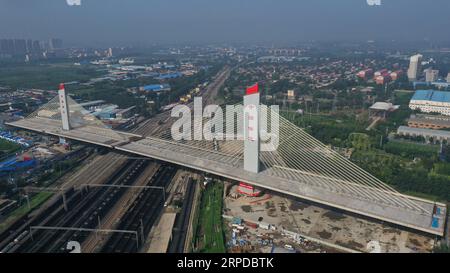 (190730) -- BAODING, 30 juillet 2019 -- cette photo aérienne prise le 30 juillet 2019 montre deux parties d'un pont au-dessus du chemin de fer Beijing-Guangzhou après qu'elles ont été tournées avec succès vers leurs positions cibles en utilisant la méthode de construction pivotante à Baoding, dans la province du Hebei du nord de la Chine. La Chine a adopté la méthode de construction pivotante dans la construction de nombreux ponts pour minimiser l'interférence sur le trafic ci-dessous. La méthode permet de surmonter les contraintes de l'environnement et de la circulation, tout en raccourcissant la période de construction. (Photo de Wang Huitang/Xinhua) CHINA-HEBEI-BAODING-BRIDGE-ROTATION (CN) Xingx Banque D'Images