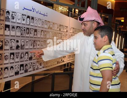 (190801) -- KOWEÏT, 1 août 2019 (Xinhua) -- Un père et son fils regardent des photos de martyrs koweïtiens de la guerre du Golfe à Koweït, Koweït, 1 août 2019. Un événement spécial a eu lieu jeudi à Koweït City à l'occasion du 29e anniversaire de l'invasion irakienne du Koweït pendant la guerre du Golfe. (Photo de Asad/Xinhua) KOWEÏT-KOWEÏT VILLE-ANNIVERSAIRE DE LA GUERRE DU GOLFE PUBLICATIONxNOTxINxCHN Banque D'Images