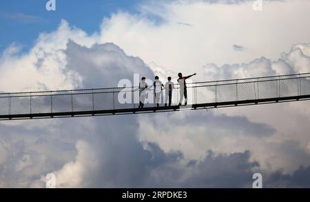 (190807) -- BEIJING, 7 août 2019 -- des gens marchent à travers le pont suspendu à Kirtipur, dans la banlieue de Katmandou, Népal, 6 août 2019. (Photo de /Xinhua) XINHUA PHOTOS DU JOUR sunilxsharma PUBLICATIONxNOTxINxCHN Banque D'Images