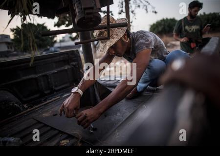 (190807) -- TRIPOLI, 7 août 2019 -- Un combattant du Gouvernement d'entente nationale (GNA) soutenu par l'ONU répare un véhicule endommagé dans un camp près de la ligne de front Salah Al-DIN à Tripoli, en Libye, le 7 août 2019. La Libye est embourbée dans les conflits et le chaos depuis la chute de l’ancien dirigeant Mouammar Kadhafi en 2011. (Photo de /Xinhua) LIBYE-TRIPOLI-CONFLIT AmruxSalahuddien PUBLICATIONxNOTxINxCHN Banque D'Images