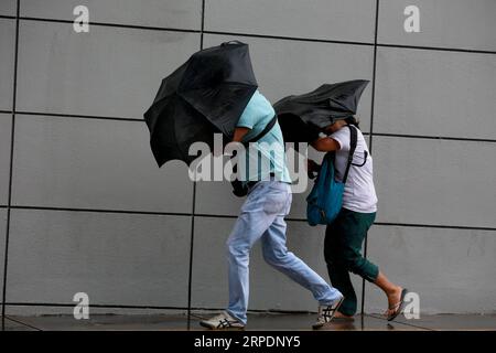 (190809) -- QUEZON CITY, 9 août 2019 -- les gens utilisent leurs parapluies pour braver les vents forts et les fortes pluies à Quezon City, Philippines, 9 août 2019.) PHILIPPINES-QUEZON-VENT FORT ET FORTES PLUIES ROUELLEXUMALI PUBLICATIONXNOTXINXCHN Banque D'Images