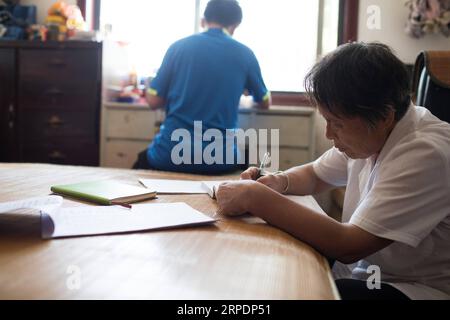 (190809) -- NANCHANG, 9 août 2019 -- Gao Yinshui étudie avec son petit-fils Chen Hailin dans le village de Lixin de la ville de Meiling dans le district de Wanli de la ville de Nanchang, province de Jiangxi dans l'est de la Chine, 8 août 2019. Presque tous les jours au cours des quatre dernières décennies, Gao Yinshui, médecin de village de 69 ans, marche sur des kilomètres sur des routes de montagne pour voir ses patients dans neuf villages différents. Fin 1970, la mère de Gao a eu une urgence et a eu la chance d être sauvée par un médecin rural local. À cause de cela, Gao Yinshui a renoncé à l'opportunité d'être enseignant et a choisi de devenir médecin rural. Cependant, elle n'a pas de médecine Banque D'Images