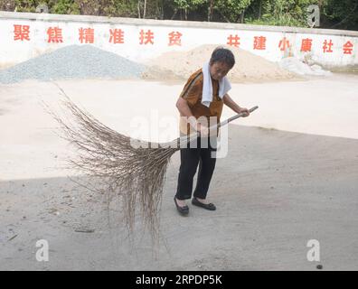 (190809) -- NANCHANG, 9 août 2019 -- Gao Yinshui nettoie la cour d'une clinique dans le village de Lixin de la ville de Meiling dans le district de Wanli de la ville de Nanchang, province de Jiangxi dans l'est de la Chine, 8 août 2019. Presque tous les jours au cours des quatre dernières décennies, Gao Yinshui, médecin de village de 69 ans, marche sur des kilomètres sur des routes de montagne pour voir ses patients dans neuf villages différents. Fin 1970, la mère de Gao a eu une urgence et a eu la chance d être sauvée par un médecin rural local. À cause de cela, Gao Yinshui a renoncé à l'opportunité d'être enseignant et a choisi de devenir médecin rural. Cependant, elle n'a aucune base médicale Banque D'Images