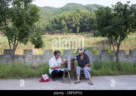 (190809) -- NANCHANG, 9 août 2019 -- Gao Yinshui vérifie la pression sanguine d'un villageois dans le village de Lixin de la ville de Meiling dans le district de Wanli de la ville de Nanchang, province de Jiangxi dans l'est de la Chine, 8 août 2019. Presque tous les jours au cours des quatre dernières décennies, Gao Yinshui, médecin de village de 69 ans, marche sur des kilomètres sur des routes de montagne pour voir ses patients dans neuf villages différents. Fin 1970, la mère de Gao a eu une urgence et a eu la chance d être sauvée par un médecin rural local. À cause de cela, Gao Yinshui a renoncé à l'opportunité d'être enseignant et a choisi de devenir médecin rural. Cependant, elle n'a pas de fou médical Banque D'Images