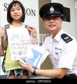 (190810) -- BEIJING, le 10 août 2019 -- Une enfant se rend au poste de police central pour exprimer son soutien à la force policière de Hong Kong, dans le sud de la Chine, le 10 août 2019.) Xinhua Headlines : Hong Kong exprime son soutien à la police, appelant à la fin de la violence WuxXiaochu PUBLICATIONxNOTxINxCHN Banque D'Images