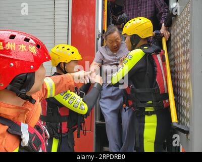 (190810) -- WENZHOU, 10 août 2019 -- les pompiers transfèrent les personnes bloquées par les inondations dans le canton de Qingjiang de la ville de Leqing, province de Zhejiang dans l'est de la Chine, 10 août 2019. Le typhon Lekima, le neuvième de l'année, a touché terre samedi à Wenling City. Des travaux de sauvetage et de nettoyage ont été effectués dans toutes les parties de la province du Zhejiang. CHINE-ZHEJIANG-TYPHON LEKIMA-SAUVETAGE (CN) ZONGXHUI PUBLICATIONXNOTXINXCHN Banque D'Images