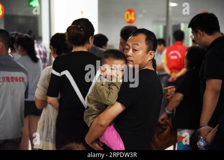 (190812) -- SHOUGUANG, 12 août 2019 -- des gens attendent pour prendre des repas sur un site de relocalisation, à Shouguang, dans la province du Shandong de l est de la Chine, 12 août 2019. Environ 93 000 résidents locaux ont été relocalisés alors que le typhon Lekima a fait des ravages dans certaines parties de Shouguang.) CHINE-SHANDONG-TYPHOON-LEKIMA-RELOCALISATION (CN) WANGXKAI PUBLICATIONXNOTXINXCHN Banque D'Images