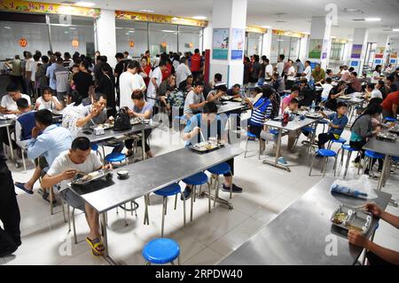 (190812) -- SHOUGUANG, 12 août 2019 -- les gens prennent des repas dans un collège, qui sert maintenant de site de relocalisation, à Shouguang, dans la province du Shandong de l est de la Chine, 12 août 2019. Environ 93 000 résidents locaux ont été relocalisés alors que le typhon Lekima a fait des ravages dans certaines parties de Shouguang.) CHINE-SHANDONG-TYPHOON-LEKIMA-RELOCALISATION (CN) WANGXKAI PUBLICATIONXNOTXINXCHN Banque D'Images