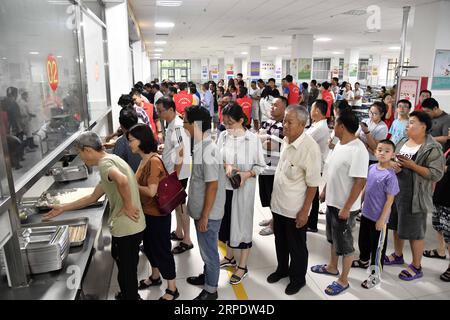 (190812) -- SHOUGUANG, 12 août 2019 -- les gens font la queue pour prendre des repas dans un collège, qui sert maintenant de site de relocalisation, à Shouguang, dans la province du Shandong de l est de la Chine, le 12 août 2019. Environ 93 000 résidents locaux ont été relocalisés alors que le typhon Lekima a fait des ravages dans certaines parties de Shouguang.) CHINE-SHANDONG-TYPHOON-LEKIMA-RELOCALISATION (CN) GUOXXULEI PUBLICATIONXNOTXINXCHN Banque D'Images