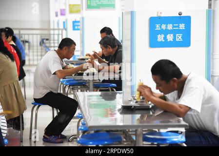 (190812) -- SHOUGUANG, 12 août 2019 -- les gens prennent des repas dans un collège, qui sert maintenant de site de relocalisation, à Shouguang, dans la province du Shandong de l est de la Chine, 12 août 2019. Environ 93 000 résidents locaux ont été relocalisés alors que le typhon Lekima a fait des ravages dans certaines parties de Shouguang.) CHINE-SHANDONG-TYPHOON-LEKIMA-RELOCALISATION (CN) WANGXKAI PUBLICATIONXNOTXINXCHN Banque D'Images