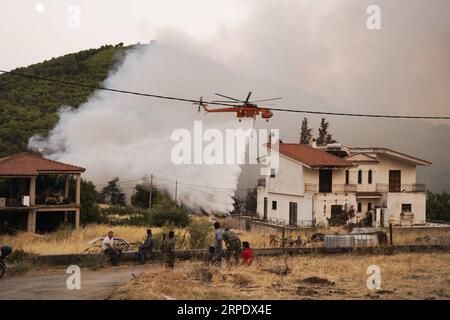 (190813) -- ÎLE D'EVIA (GRÈCE), 13 août 2019 -- Un hélicoptère larguant est vu combattre un feu de forêt près du village de Makrymalli sur l'île d'Evia, en Grèce, le 13 août 2019. Les pompiers grecs ont combattu les plus grands incendies de forêt de cet été qui ont fait rage sur deux fronts importants près d'Athènes mardi, ont déclaré les autorités locales. Plus de 500 habitants ont été évacués de trois villages par mesure de précaution, selon les pompiers. (Photo de Nick Paleologos/Xinhua) GRÈCE-ÎLE D'EVIA-FEU DE FORÊT NixKe¤palaiaoluogesi PUBLICATIONxNOTxINxCHN Banque D'Images