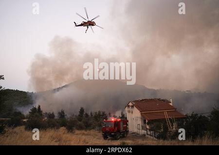 (190813) -- ÎLE D'EVIA (GRÈCE), 13 août 2019 -- Un hélicoptère larguant est vu combattre un feu de forêt près du village de Makrymalli sur l'île d'Evia, en Grèce, le 13 août 2019. Les pompiers grecs ont combattu les plus grands incendies de forêt de cet été qui ont fait rage sur deux fronts importants près d'Athènes mardi, ont déclaré les autorités locales. Plus de 500 habitants ont été évacués de trois villages par mesure de précaution, selon les pompiers. (Photo de Nick Paleologos/Xinhua) GRÈCE-ÎLE D'EVIA-FEU DE FORÊT NixKe¤palaiaoluogesi PUBLICATIONxNOTxINxCHN Banque D'Images