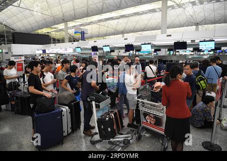 (190815) -- HONG KONG, 15 août 2019 -- les voyageurs font la queue pour s'enregistrer à l'aéroport international de Hong Kong, à Hong Kong, Chine méridionale, 15 août 2019. Le fonctionnement de l'aéroport international de Hong Kong est revenu à la normale jeudi, a déclaré l'Autorité aéroportuaire de Hong Kong. Le fonctionnement de l aéroport avait été sérieusement affecté au cours des derniers jours par des rassemblements illégaux, avec 979 vols annulés, a déclaré le directeur général de l autorité aéroportuaire Fred Lam lors d une conférence de presse mercredi. Lui Siu Wai) CHINA-HONG KONG-AIRPORT (CN) LyuxXiaowei PUBLICATIONxNOTxINxCHN Banque D'Images