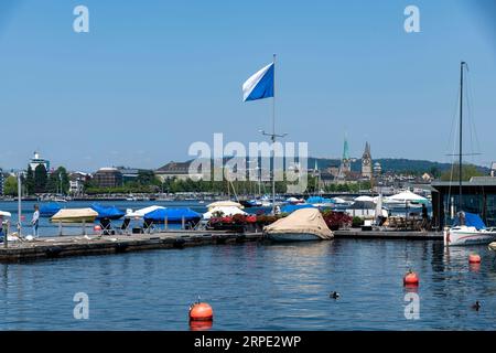 Zurich, Suisse-27 mai 2023 ; vue sur la rivière Limmat avec quai de location de bateaux dans le centre-ville ou Altstadt avec église Fraumünster et Quaibrücke agai Banque D'Images