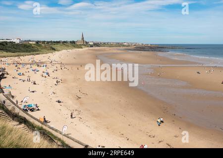 Les gens profitant du soleil sur la plage de Tynemouth Longsands, Angleterre, Royaume-Uni Banque D'Images