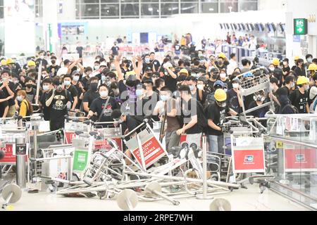 (190820) -- BEIJING, 20 août 2019 () -- des radicaux violents bloquent un passage à l'aéroport international de Hong Kong dans le sud de la Chine Hong Kong, 13 août 2019. () titres : Comment les forces extérieures ont enflammé les tensions à Hong Kong Xinhua PUBLICATIONxNOTxINxCHN Banque D'Images
