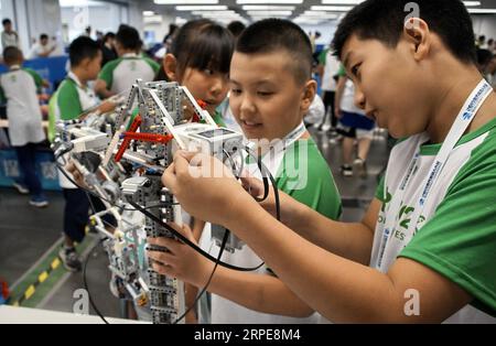 (190821) -- BEIJING, 21 août 2019 -- deux jeunes participants examinent leurs équipements devant les Champions du World robot Contest à Beijing, capitale de la Chine, le 21 août 2019. Plus de 1 000 équipes de dix pays et régions participeront au World robot Contest Champions. CHINA-BEIJING-WORLD ROBOT CONTEST CHAMPIONS (CN) LIXXIN PUBLICATIONXNOTXINXCHN Banque D'Images