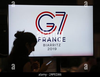 (190825) -- BIARRITZ, le 25 août 2019 -- Un journaliste se fait silhouetter sur un écran de télévision au centre de presse du sommet du G7 à Biarritz, France, le 25 août 2019. Les dirigeants des sept pays les plus industrialisés du monde ont entamé le 45e sommet du groupe divisé, assombri par un tas de questions difficiles avec des tensions commerciales à l ordre du jour, samedi soir à la station balnéaire française de Biarritz.) FRANCE-BIARRITZ-G7 SUMMIT-MEDIA GaoxJing PUBLICATIONxNOTxINxCHN Banque D'Images