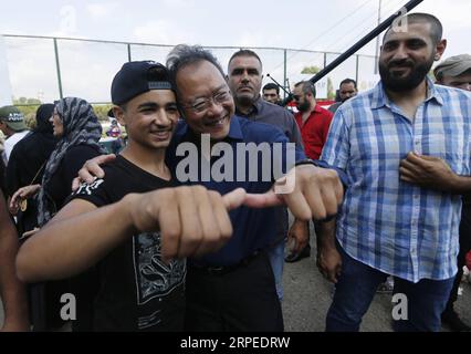 190826 -- PÉKIN, 26 août 2019 -- violoncelliste Yo-Yo Ma 2nd L, pose devant un jeune homme à Beyrouth, Liban, le 25 août 2019. Environ 300 jeunes et enfants du Liban, de Syrie, de Palestine et d'autres endroits de la région se sont joints dimanche au violoncelliste Yo-Yo Ma et aux artistes du Silkroad ensemble pour transformer les toits et les rues du quartier Qasqas de Beyrouth en une vaste scène interactive. Photo de Bilal Jawich/XINHUA XINHUA PHOTOS DU JOUR LixLiangyong PUBLICATIONxNOTxINxCHN Banque D'Images