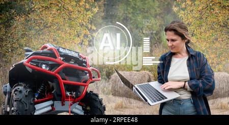 Femme agricultrice tient l’ordinateur dans sa main et les commandes d’un tracteur autonome avec intelligence artificielle. Transformation numérique en agriculture Banque D'Images