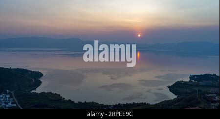 (190826) -- YUXI, 26 août 2019 -- la photo prise le 26 août 2019 montre le lac Fuxian au crépuscule à Yuxi, dans la province du Yunnan du sud-ouest de la Chine. En 2005, le 26 août a été désigné Journée d action pour la protection du lac Fuxian afin de sensibiliser aux questions de protection de l environnement du lac. Environ 220 000 alevins de poissons indigènes Kanglang ont été relâchés dans le lac lors de la Journée d'action de protection du lac Fuxian de 2019. ) CHINE-YUNNAN-FUXIAN LAKE-PROTECTION DE L'ENVIRONNEMENT (CN) JIANGXWENYAO PUBLICATIONXNOTXINXCHN Banque D'Images