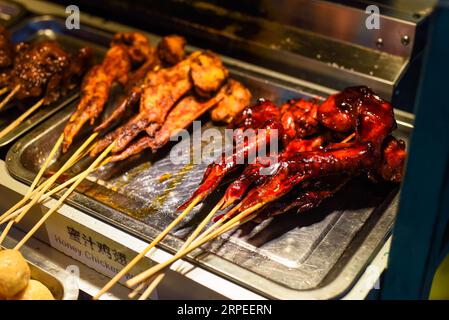 Ailes de poulet grillées au miel dans la cuisine de rue Jalan Alor à Kuala Lumpur Banque D'Images
