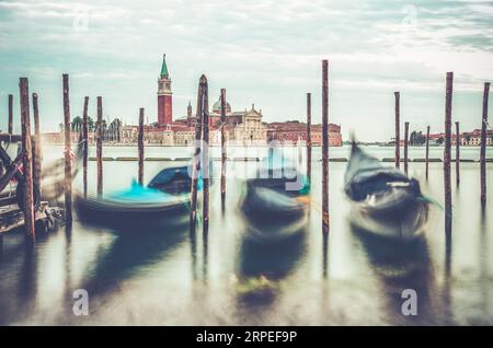 Photo avec gondoles amarrées sur le Grand Canal près de la place Saint Marc, à Venise en Italie avec l'église San Giorgio Maggiore en arrière-plan. Banque D'Images