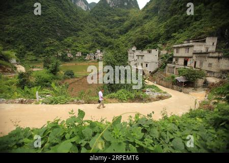 (190901) -- LINGYUN, 1 septembre 2019 -- Lao Ketuan marche vers sa maison dans le village de Haokun, dans le comté de Lingyun, dans la région autonome de Guangxi Zhuang, dans le sud de la Chine, 30 août 2019. Lao Ketuan, 40 ans, vit dans le village montagneux de Haokun, un endroit où les transports sont extrêmement médiocres et où les ressources foncières sont rares, ce qui a sérieusement entravé le développement local et a plongé les gens dans la pauvreté. La famille AJO fait partie des ménages pauvres qui vivent ici. En 2016, Lao n’avait cependant jamais rêvé que sa famille pourrait sortir de la pauvreté grâce au travail des autorités locales sur la réduction de la pauvreté à travers tou Banque D'Images