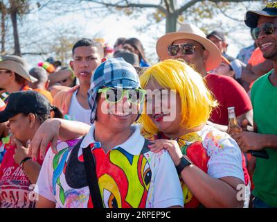 Barranquilla, Atlantico, Colombie - février 18 2023 : un homme colombien portant un T-shirt coloré, des lunettes et une casquette se tient à côté d'une femme portant un Yell Banque D'Images