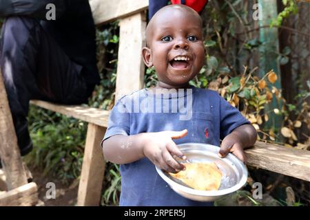 (190903) -- BEIJING, 3 septembre 2019 -- Un enfant tient un samosa à Nairobi, capitale du Kenya, le 1 septembre 2019. Samosa est une collation frite traditionnelle de forme triangulaire au Kenya, remplie de légumes épicés, de bœuf haché, de poulet ou de poisson. PHOTOS XINHUA DU JOUR WangxTeng PUBLICATIONxNOTxINxCHN Banque D'Images