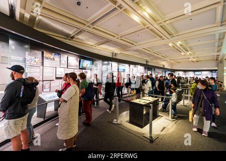 Vue intérieure, les gens regardent des expositions dans la salle de la table des médias dédiée aux dangers de la guerre nucléaire dans le musée de la paix d'Hiroshima. Banque D'Images