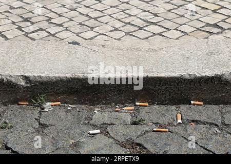 (190904) -- LISBONNE, 4 septembre 2019 -- des mégots de cigarettes sont vus sur le trottoir d'une rue de Lisbonne, Portugal, le 4 septembre 2019. Le Portugal a introduit mercredi une loi stricte visant à lutter contre les fumeurs qui jettent les mégots de cigarette sur le sol en public. La nouvelle loi qui approuve des mesures pour la collecte et le traitement des déchets de tabac entre en vigueur mercredi. Quiconque jette sur le sol sera puni d'amendes entre 25 et 250 euros (27,6 dollars américains à 276 dollars américains). (Photo de Pedro Fiuza/Xinhua) PORTUGAL-LISBON-LAW-CIGARETTE LANCEUR DE MÉGOTS PetroxFiuza PUBLICATIONxN Banque D'Images