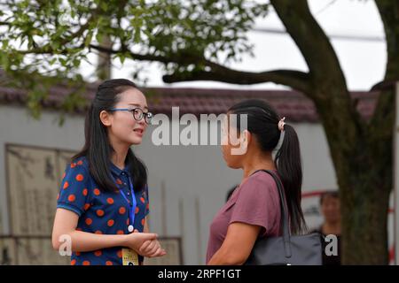 (190909) -- NANCHANG, 9 septembre 2019 -- Tu Youyou (à gauche) parle avec une mère de la performance de son enfant en vacances à l'école primaire Shangban dans le canton de Luoting, district de Wanli de la ville de Nanchang, province de Jiangxi dans l'est de la Chine, 1 septembre 2019. Après avoir obtenu son diplôme de l'éducation normale en 2013, Tu a travaillé comme assistante dans un établissement de formation et a fait du travail communautaire, mais elle a toujours rêvé d'être enseignante. En 2016, elle réussit l'examen de recrutement d'enseignants de la province du Jiangxi et devient enseignante rurale. Au cours des trois dernières années, Tu Youyou a gagné la reconnaissance de ses parents élèves Banque D'Images