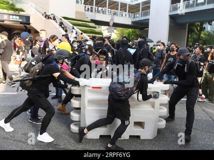 (190915) -- HONG KONG, 15 septembre 2019 -- des émeutiers érigent des barricades près des bureaux gouvernementaux de la région administrative spéciale de Hong Kong (RAS de Hong Kong) à Hong Kong, dans le sud de la Chine, le 15 septembre 2019. Des émeutiers ont incendié des zones centrales et de l'Amirauté, ont lancé des bombes à essence sur les bureaux du gouvernement de la RAS de Hong Kong et ont vandalisé les gares ferroviaires de transport en commun (MTR) dimanche. CHINA-HONG KONG-RIOTER-VIOLENCE (CN) LUXHANXIN PUBLICATIONXNOTXINXCHN Banque D'Images