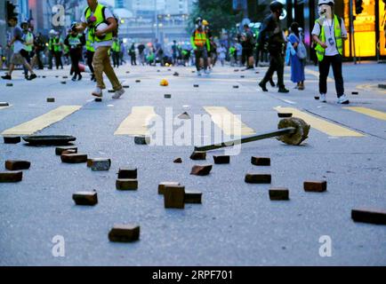 (190915) -- HONG KONG, 15 septembre 2019 -- des émeutiers jettent des briques sur la route à WAN Chai de Hong Kong, Chine méridionale, 15 septembre 2019. Des émeutiers ont incendié des zones centrales et de l'Amirauté, ont lancé des bombes à essence sur les bureaux du gouvernement de la région administrative spéciale de Hong Kong (HKSAR) et ont vandalisé des gares ferroviaires de transport en commun (MTR) dimanche. CHINA-HONG KONG-RIOTER-VIOLENCE (CN) WANGXSHEN PUBLICATIONXNOTXINXCHN Banque D'Images