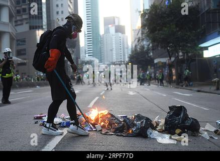 (190915) -- HONG KONG, 15 septembre 2019 -- Un émeutier met le feu à Hennessy Road à Hong Kong, Chine méridionale, le 15 septembre 2019. Des émeutiers ont incendié des zones centrales et de l'Amirauté, ont lancé des bombes à essence sur les bureaux du gouvernement de la région administrative spéciale de Hong Kong (HKSAR) et ont vandalisé des gares ferroviaires de transport en commun (MTR) dimanche. CHINA-HONG KONG-RIOTER-VIOLENCE (CN) LUXHANXIN PUBLICATIONXNOTXINXCHN Banque D'Images