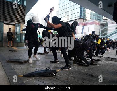 (190915) -- HONG KONG, 15 septembre 2019 -- des émeutiers endommagent la route dans la région de l'Amirauté de Hong Kong, Chine méridionale, 15 septembre 2019. Des émeutiers ont incendié des zones centrales et de l'Amirauté, ont lancé des bombes à essence sur les bureaux du gouvernement de la région administrative spéciale de Hong Kong (HKSAR) et ont vandalisé des gares ferroviaires de transport en commun (MTR) dimanche. CHINA-HONG KONG-RIOTER-VIOLENCE (CN) LIXGANG PUBLICATIONXNOTXINXCHN Banque D'Images