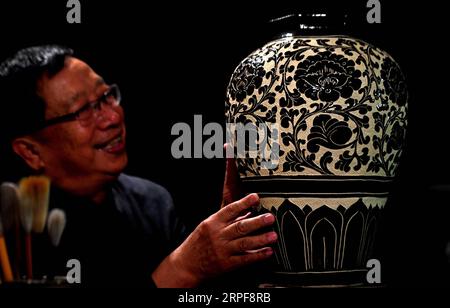 (190917) -- SHIJIAZHUANG, 17 septembre 2019 -- Liu Lizhong regarde son travail de four à Cizhou dans un musée de la ville de Handan, province du Hebei, dans le nord de la Chine, le 12 septembre 2019. Liu Lizhong, 75 ans, est un héritier de la technique de tir du four de Cizhou. En tant que quatrième génération dans sa famille de fabrication de porcelaine, Liu s'est consacré à la préservation et à la recherche des compétences traditionnelles de brûlage de four, et a hérité avec succès des 72 procédures intactes de brûlage de four de Cizhou. Ayant recruté plus de 100 apprentis, il a dit que son rêve était de transmettre le métier traditionnel aux jeunes générations. CHINE-HEBEI-CIZHOU Banque D'Images