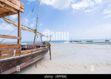 Bateaux de pêche en bois amarrés sur la plage en raison de marée basse au village de Kendwa, journée ensoleillée, Zanzibar, Tanzanie Banque D'Images