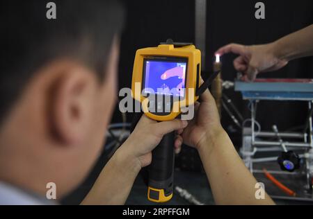 190923 -- CHENGDU, 23 septembre 2019 -- Zhang Chaoyang, doctorant à l'Université des sciences et technologies électroniques de Chine UESTC, utilise une caméra infrarouge pour tester l'effet du jet de plasma sur la peau humaine dans l'UESTC à Chengdu, dans la province du Sichuan du sud-ouest de la Chine, le 11 septembre 2019. Récemment, des chercheurs du département de physique et d'électronique, de l'école des sciences électroniques et de l'ingénierie de l'UESTC ont développé avec succès un nouveau jet plasma portable après deux ans d'expériences scientifiques. Les plasmas sont excités par l'énergie micro-ondes. En concevant une structure spéciale pour Banque D'Images