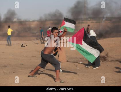 190927 -- GAZA, 27 septembre 2019 Xinhua -- Un manifestant palestinien utilise une fronde pour lancer des pierres sur les troupes israéliennes lors d'affrontements à la frontière Gaza-Israël, à l'est de la ville de Khan Younis, dans le sud de la bande de Gaza, le 27 septembre 2019. Un jeune palestinien a été abattu vendredi par des tirs de l armée israélienne lors des manifestations hebdomadaires anti-israéliennes le long de la frontière entre Gaza et Israël, a déclaré le ministère palestinien de la Santé à Gaza. Au moins 63 Palestiniens ont été blessés lors d'une manifestation d'une journée dans l'est de la bande de Gaza, a déclaré Ashraf al-Qedra, porte-parole du ministère de la Santé à Gaza. Photo de Yasser Qudih/Xinhua MIDEAST-GAZA- Banque D'Images