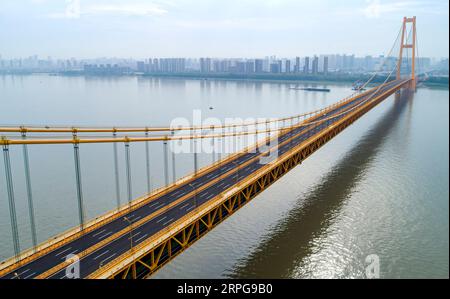 191008 -- WUHAN, 8 octobre 2019 -- une photo aérienne prise le 25 septembre 2019 montre le pont du fleuve Yangsigang Yangtze à Wuhan, capitale de la province du Hubei en Chine centrale. Le pont suspendu à deux étages avec la plus longue travée du monde a été ouvert à la circulation à Wuhan le 8 octobre. Le pont routier à deux étages sur le fleuve Yangtze, avec une travée principale de 1 700 mètres de long, s'étend sur 4,13 km de longueur totale. Le pont supérieur du 10e pont du fleuve Yangtze a six voies avec une vitesse prévue de 80 km/h tandis que le pont inférieur a également six voies mais avec une vitesse prévue de 60 km/h. CHINE-HUBEI-WUHAN-DOUBLE-PONT SUSPE Banque D'Images