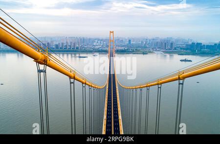 191008 -- WUHAN, 8 octobre 2019 -- une photo aérienne prise le 25 septembre 2019 montre le pont du fleuve Yangsigang Yangtze à Wuhan, capitale de la province du Hubei en Chine centrale. Le pont suspendu à deux étages avec la plus longue travée du monde a été ouvert à la circulation à Wuhan le 8 octobre. Le pont routier à deux étages sur le fleuve Yangtze, avec une travée principale de 1 700 mètres de long, s'étend sur 4,13 km de longueur totale. Le pont supérieur du 10e pont du fleuve Yangtze a six voies avec une vitesse prévue de 80 km/h tandis que le pont inférieur a également six voies mais avec une vitesse prévue de 60 km/h. CHINE-HUBEI-WUHAN-DOUBLE-PONT SUSPE Banque D'Images