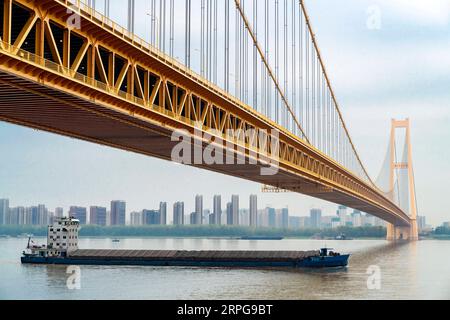 191008 -- WUHAN, 8 octobre 2019 -- la photo prise le 25 septembre 2019 montre le pont du fleuve Yangsigang Yangtze à Wuhan, capitale de la province du Hubei en Chine centrale. Le pont suspendu à deux étages avec la plus longue travée du monde a été ouvert à la circulation à Wuhan le 8 octobre. Le pont routier à deux étages sur le fleuve Yangtze, avec une travée principale de 1 700 mètres de long, s'étend sur 4,13 km de longueur totale. Le pont supérieur du 10e pont du fleuve Yangtze a six voies avec une vitesse prévue de 80 km/h tandis que le pont inférieur a également six voies mais avec une vitesse prévue de 60 km/h. CHINE-HUBEI-WUHAN-SUSPENSION À DOUBLE PONT B Banque D'Images