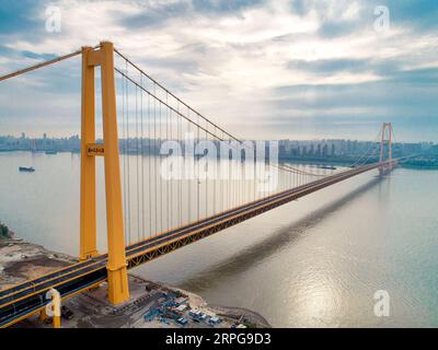 191008 -- WUHAN, 8 octobre 2019 -- une photo aérienne prise le 25 septembre 2019 montre le pont du fleuve Yangsigang Yangtze à Wuhan, capitale de la province du Hubei en Chine centrale. Le pont suspendu à deux étages avec la plus longue travée du monde a été ouvert à la circulation à Wuhan le 8 octobre. Le pont routier à deux étages sur le fleuve Yangtze, avec une travée principale de 1 700 mètres de long, s'étend sur 4,13 km de longueur totale. Le pont supérieur du 10e pont du fleuve Yangtze a six voies avec une vitesse prévue de 80 km/h tandis que le pont inférieur a également six voies mais avec une vitesse prévue de 60 km/h. CHINE-HUBEI-WUHAN-DOUBLE-PONT SUSPE Banque D'Images