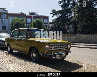 Voiture classique jaune garée dans la rue, parfait état classique FIAT 124. Photo de haute qualité Banque D'Images